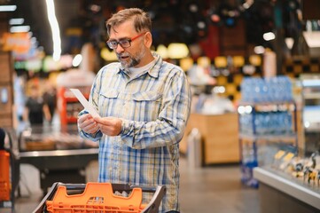 Shocked man looking at fiscal receipt in grocery store