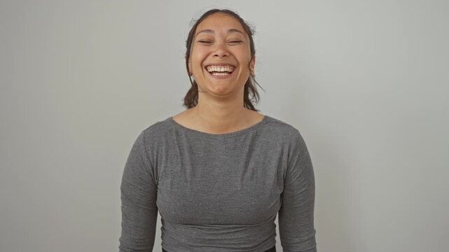 Quirky young hispanic woman standing over isolated white background, making a comical fish face by squinting eyes and puckering mouth, bringing crazy fun!