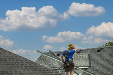 Roofer on the roof covered with bituminous shingles