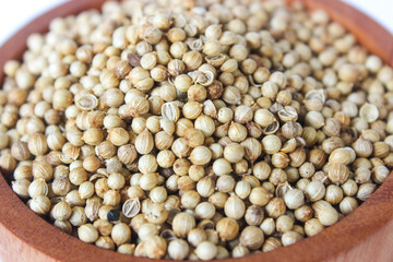 Close up White pepper seeds or Peppercorns in a wooden bowl isolated on white background.