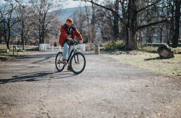 Fototapeta premium A modern hipster man on a leisurely bicycle ride, taking in the serenity of the outdoor park setting.