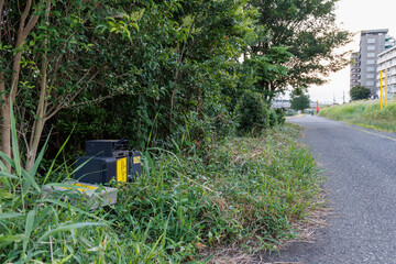 道端の草むらに不法投棄された家電