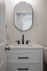 Modern Powder Room Vanity With Oval Mirror And Black Faucet Fixtures