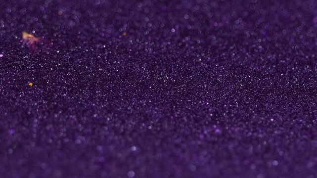 Sparkling ink spill. Glitter paint flow. Blur purple black color shiny metallic sequin sand particles fluid wave motion abstract art background with bokeh lights.