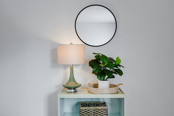 Aesthetic Corner With Lamp, Potted Plant And Round Mirror Hung On White Wall