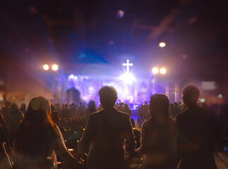worship background with hands raised in the crowd
