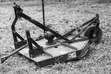 Black and white of a bush hog brush cutter on a farm.