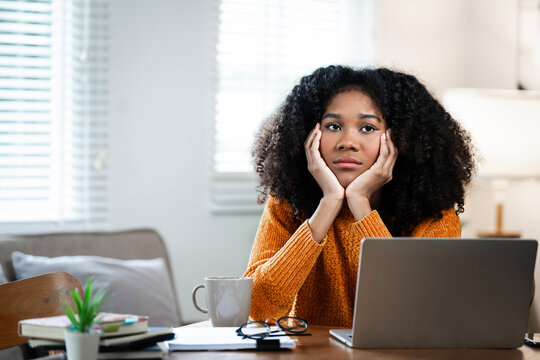 Tired african-american business woman sitting at office, feeling borring at work.