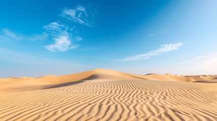 Expansive desert landscape with rolling sand dunes under a clear blue sky