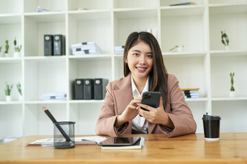  
Asian business woman Use a laptop computer and work at the office ready. plan to analyze financial reports