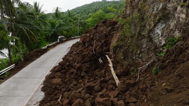 Heavy rainfall cause the landslides that block the half of the road. Camiguin, Philippines.