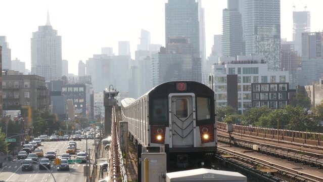 New York subway station. Metro train, metropolitan platform, United States public transportation. Elevated outdoor railway, 7 line, Queens. NYC passenger railroad traffic. Manhattan, Empire State view