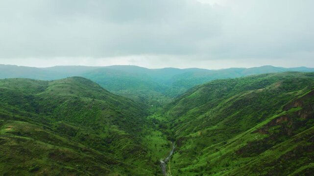 4K aerial view of Rayta Hills at Udaipur, Rajasthan, India. Green mountains and cloudy sky during monsoon season. Travel and holidays background.