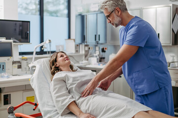 Doctor palpating woman's abdomen, using hands and steady pressure.