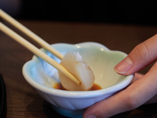 日本の和食レストランで新鮮なホタテを食べる子供の様子