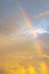 Rainbow against cloudy sunset sky. Nature background. Weather after rain.