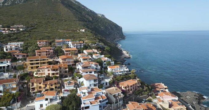 Beautiful Coastal Town Of Cala Gonone, Houses Situated On A Cliff Overlooking Ocean In Italy.