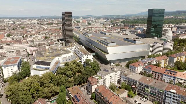 Basel messe complex surrounded by buildings and greenery on a sunny day, aerial view