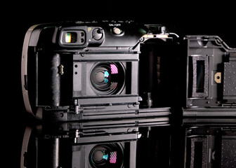 Retro film camera, close-up, back view, on black background.