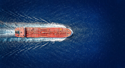 High aerial top view of a crude oil tanker traveling with speed over the ocean with copy space