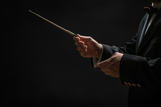 Professional conductor with baton on black background