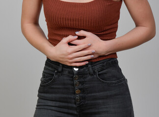 frau haöltz sich den bauch unterleib wegen schmerzen menstruation regelschmerzen bauchweh kramfp...