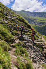 Hiker women with backpacks on a trail