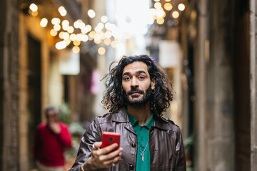 Young man using smartphone in a city center street