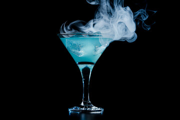 Blue cocktail with blue smoke on black background