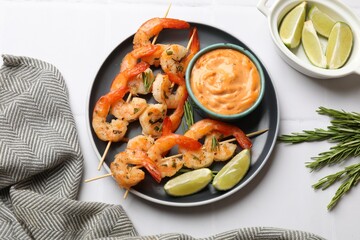 Skewers with delicious grilled shrimps served on white table, flat lay
