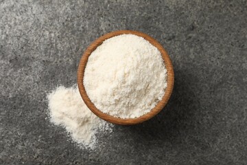 Organic coconut flour in bowl on grey table, top view