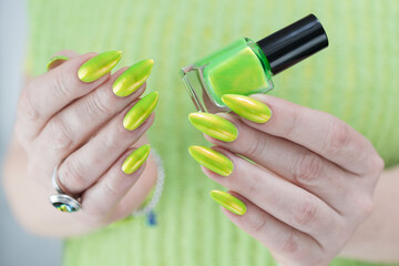 Female hand with long nails and a bright yellow green nail polish