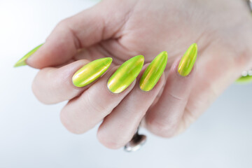 Female hand with long nails and a bright yellow green nail polish