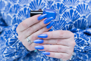 Woman's beautiful hand with long nails and bright blue manicure