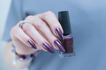 Female hands with long nails and dark purple manicure 