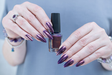 Beautiful woman's hand with long nails and multicolored nail polish, blue and brown 