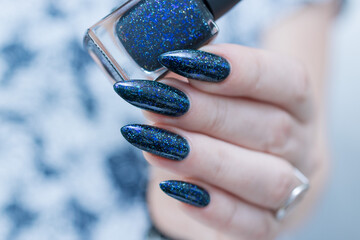 Woman's hand with long nails black and dark blue manicure