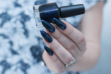 Woman's hand with long nails black and dark blue manicure