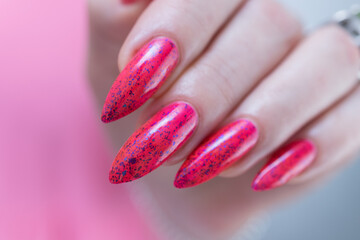 female hands with long nails and bright neon pink and red nail polish