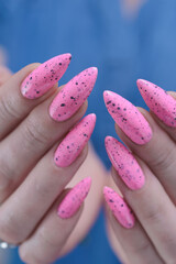 Female hands with long nails and neon light pink nail polish