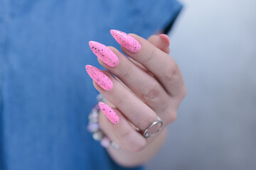 Female hands with long nails and neon light pink nail polish