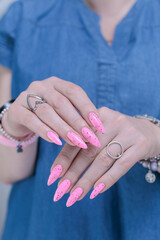 beautiful female hands with long nails and bright neon pink nail polish