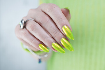 Female hand with long nails and neon yellow green manicure