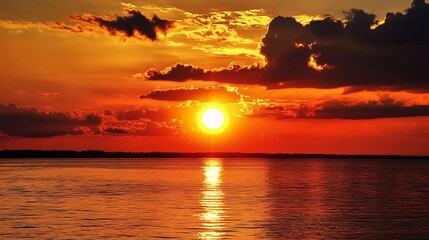 Fototapeta premium A scene featuring the sky, sun, and sea at sundown.