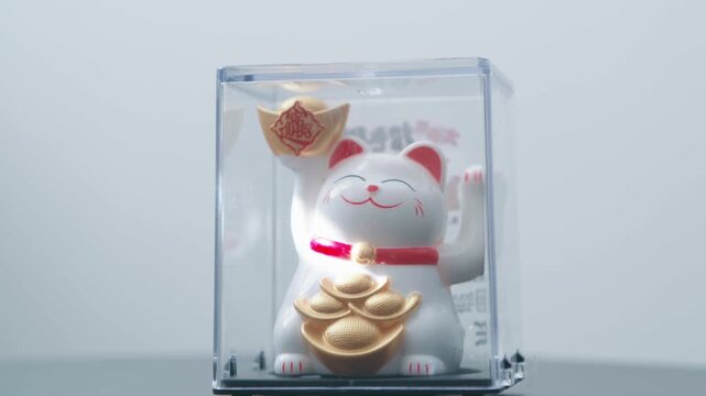 maneki neko, 招き猫, cat calling literally, the Japanese or Chinese fortune cat moves its paw as a sign of prosperity and wealth lit by the sun and powered by a solar panel