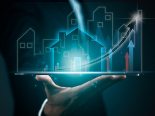 Businessman holding tablet with virtual screen of city hologram and growing business graph, real estate economic growth analysis, residential development project. Real estate business concept.