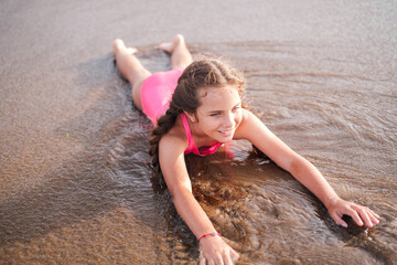 10 year old girl enjoying a day at the beach bathing at sunset. Concept: lifestyle