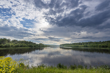 A lake with a cloudy sky in the background