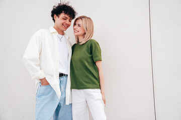 Smiling beautiful woman and her handsome boyfriend. Couple in casual summer clothes. Happy cheerful family. Female and man having fun. They posing in the street in sunny day. Having tender moments