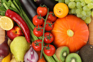 Different fresh fruits and vegetables in basket, top view